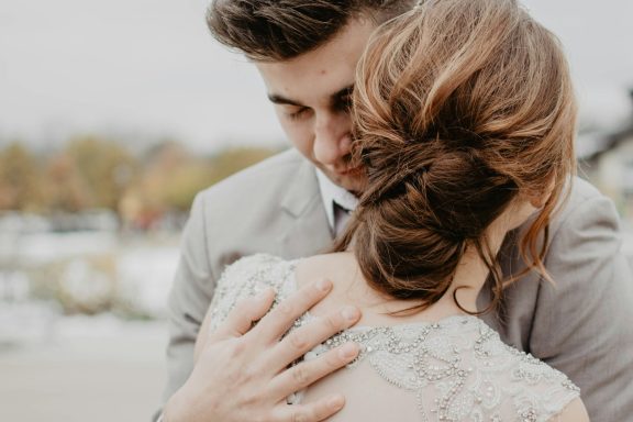 A couple embracing, with the woman’s back and hair prominently visible.