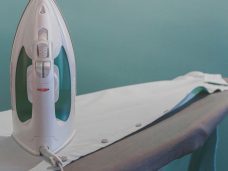 Pressed & Fresh | A steam iron on an ironing board with a light-coloured cloth.