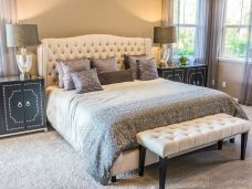 Pressed & Fresh | Modern bedroom with a tufted bed, decorative cushions, and a bench at the foot.