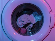 Pressed & Fresh | Laundry inside a washing machine, including crumpled clothes and socks.